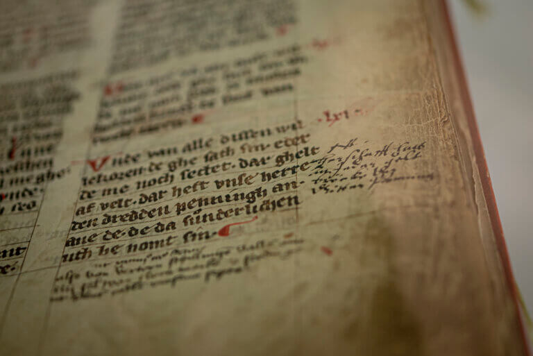 Nahaufnahme einer Buchseite. Die Seite in mit schwarzer und roter Tinte handbeschrieben. Es handelt sich um eine Statutenbuch der Stadt Göttingen aus dem 14. Jahrhundert.